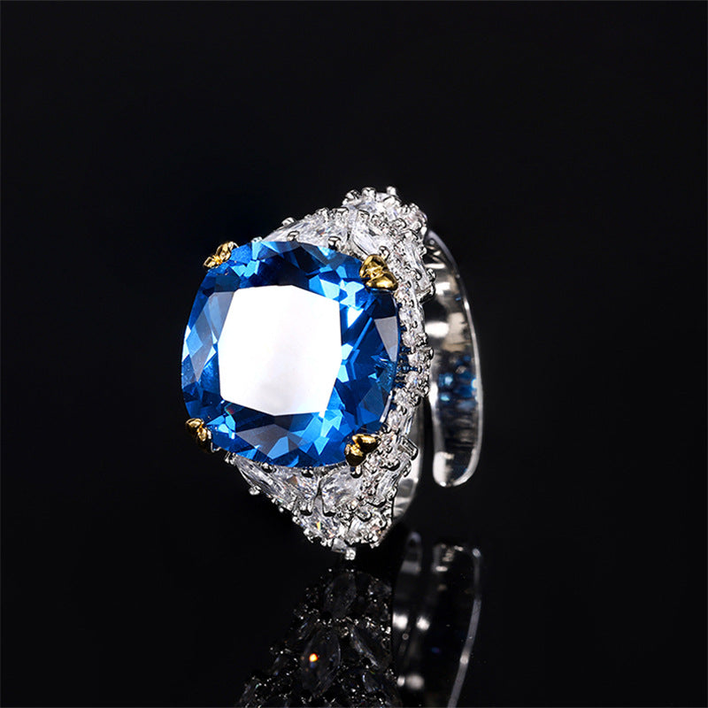 A silver plating beige cocktail brass ring, inlaid with a blue center stone and white marquise-cut zirconias.