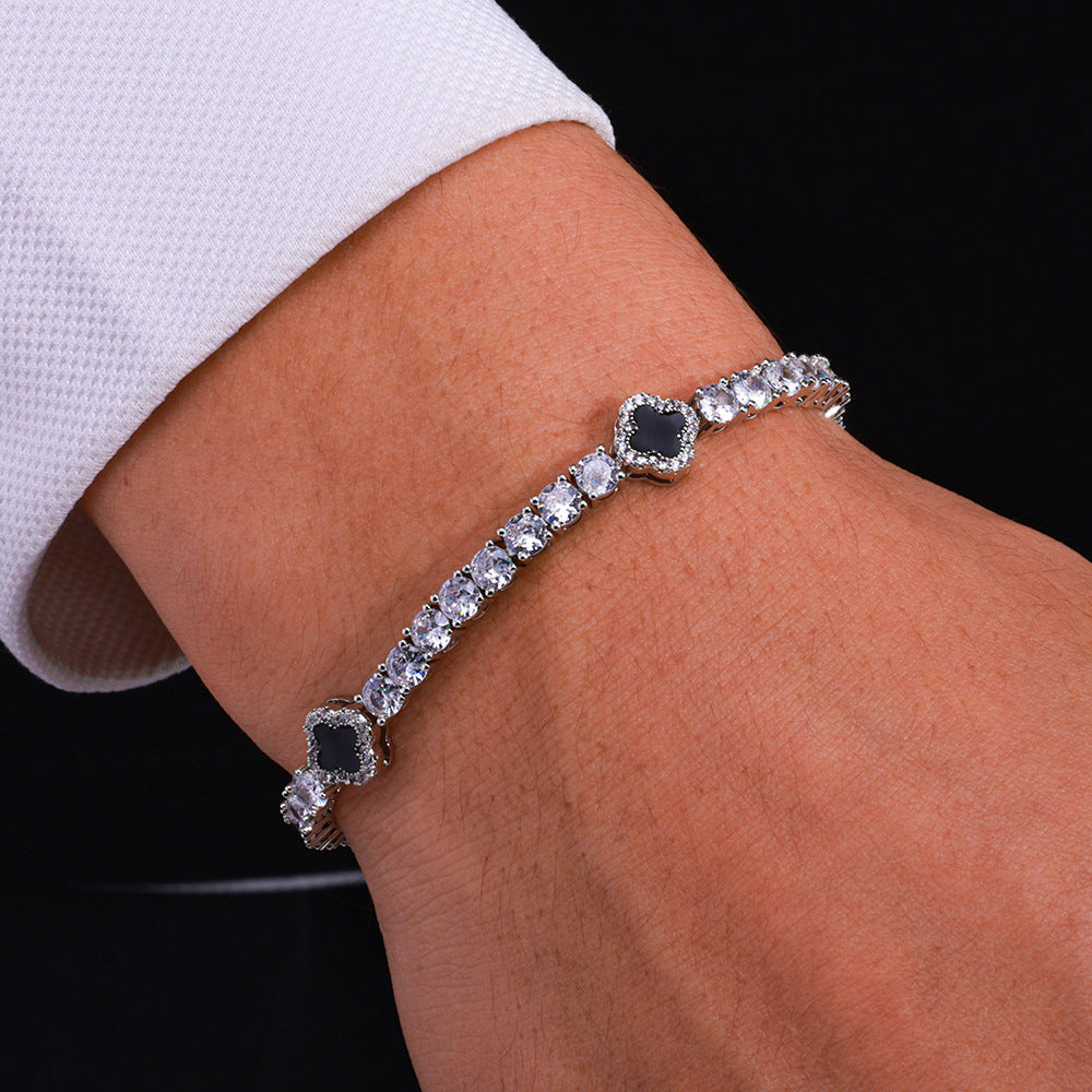 The model showcases the black enamel clover motifs tennis bracelet with silver plating.
