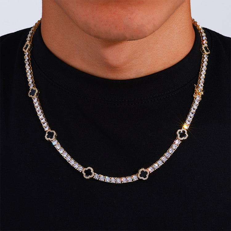 The model showcases the black enamel clover motifs tennis necklace with gold plating.