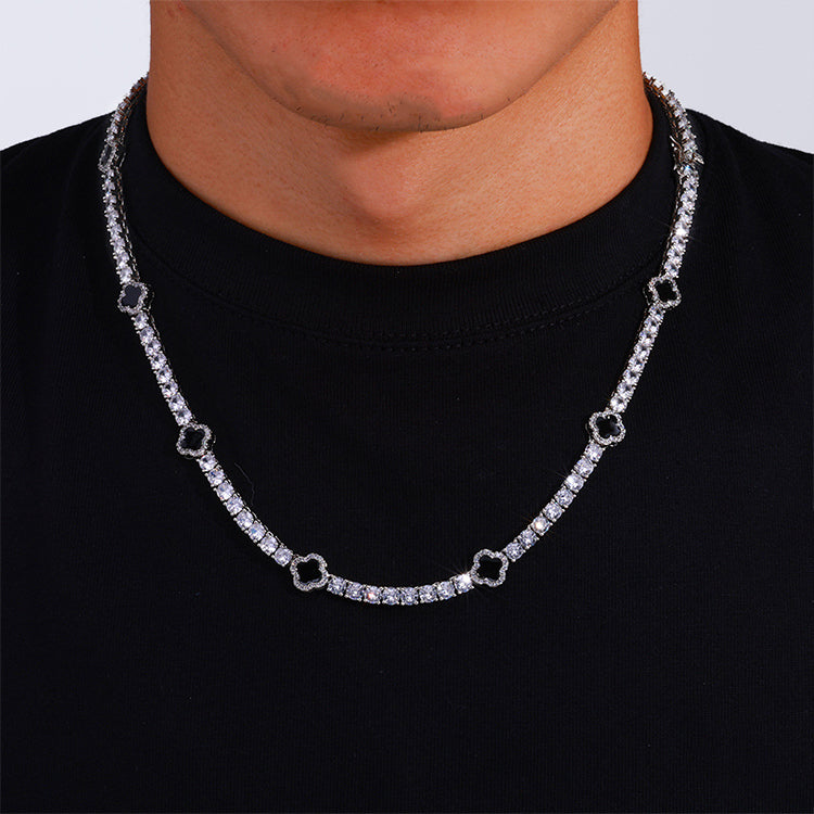 The model showcases the black enamel clover motifs tennis necklace with silver plating.