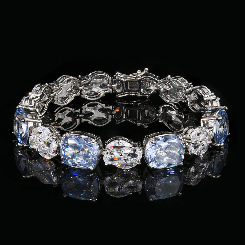 A brass bracelet alternating between light blue and white zirconia. Plating with silver.