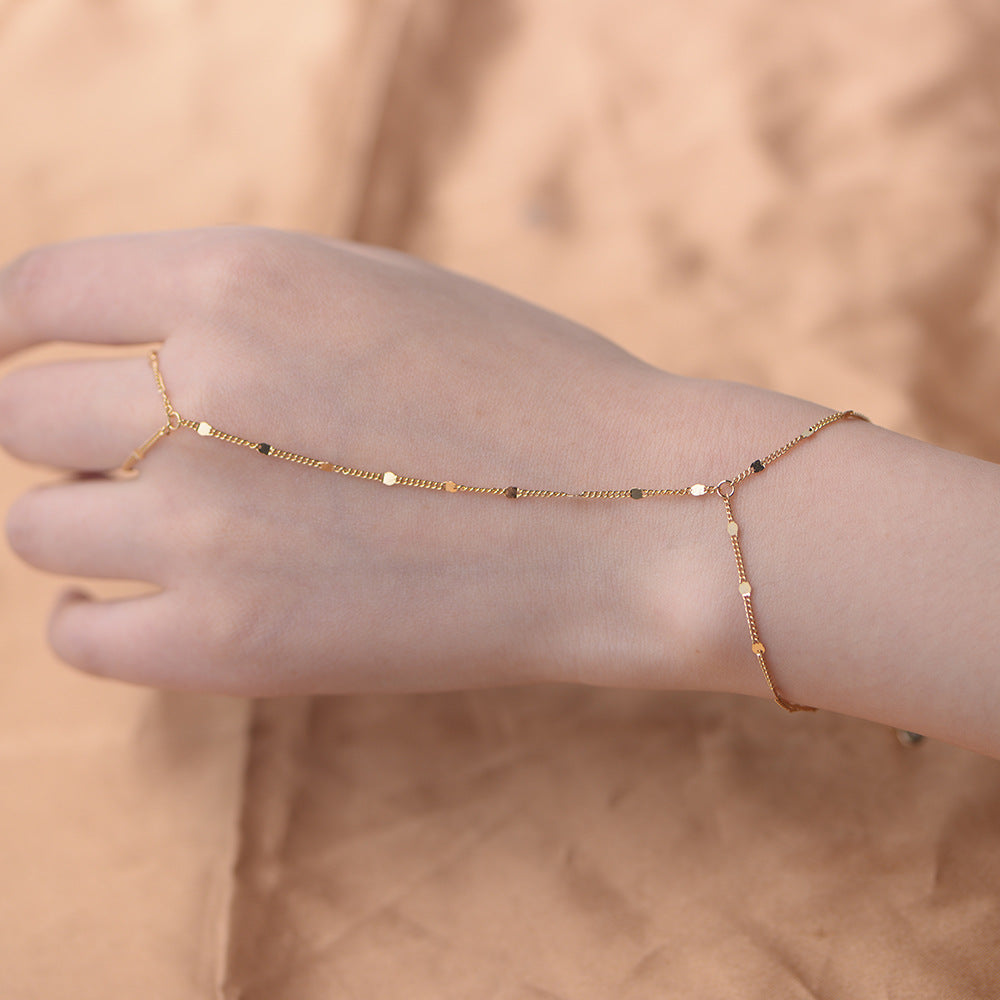 The model showcases the hand chain with gold plating.