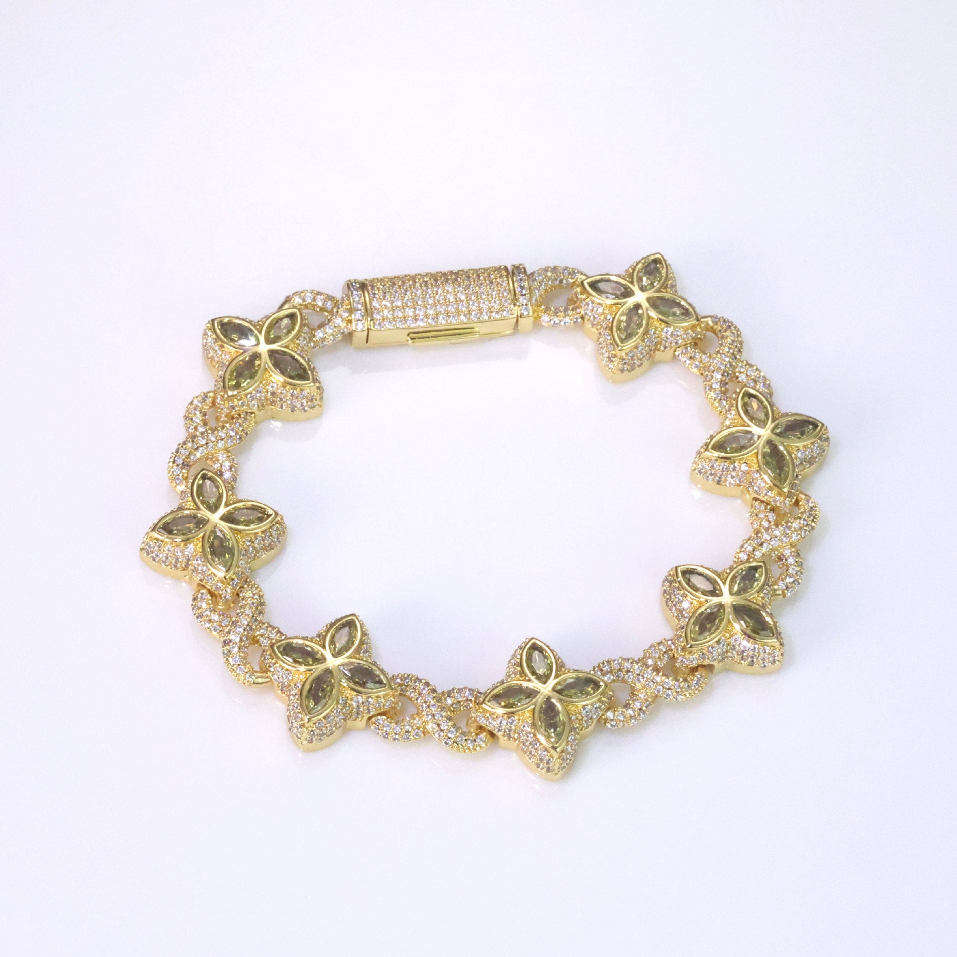 An iced out luxury big clover bracelet, infinity symbol, design in clovers with green maquise stone. Iced out box clasp. Brass with gold plating.