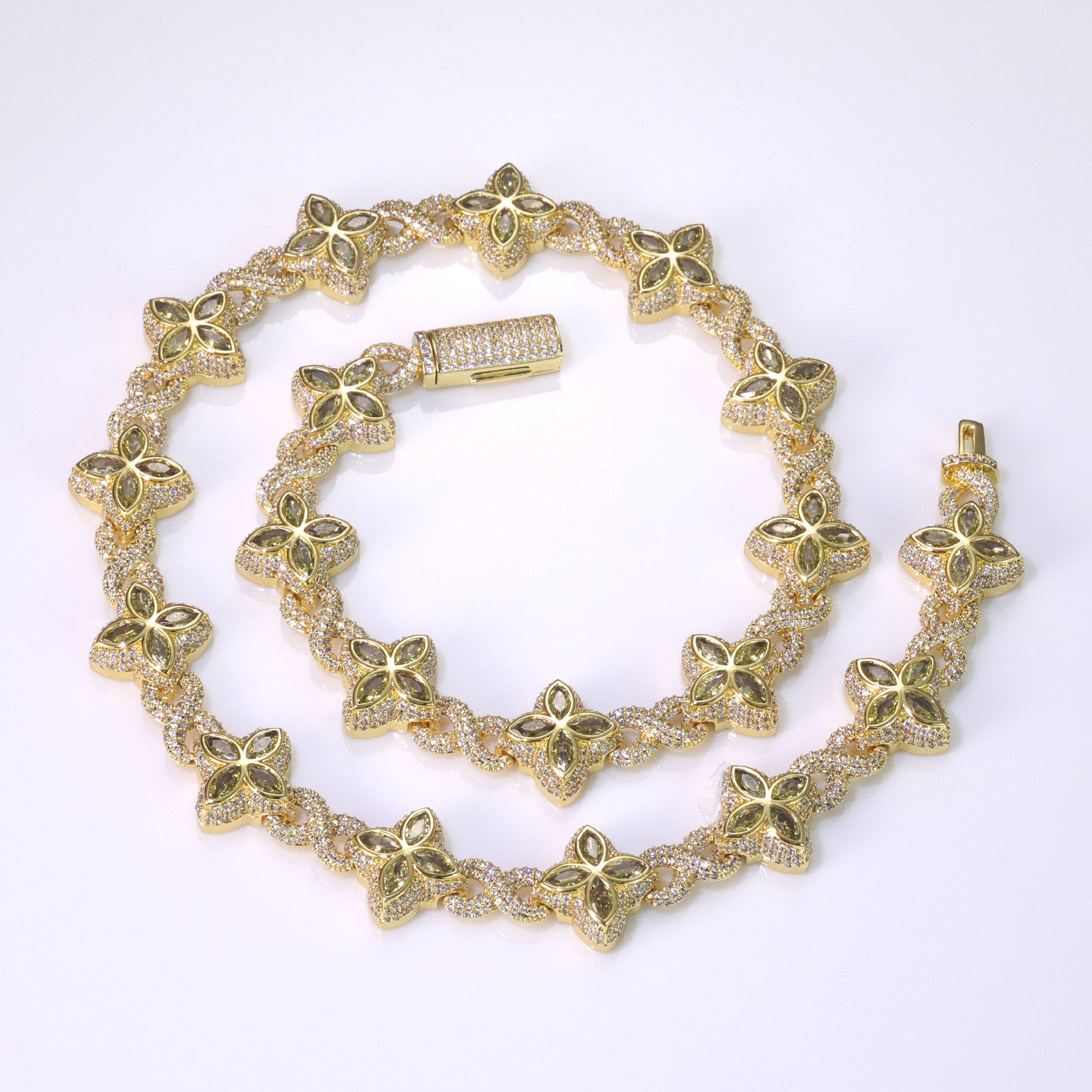 An iced out luxury big clover necklace, infinity symbol, design in clovers with green maquise stone. Iced out box clasp. Brass with gold plating.