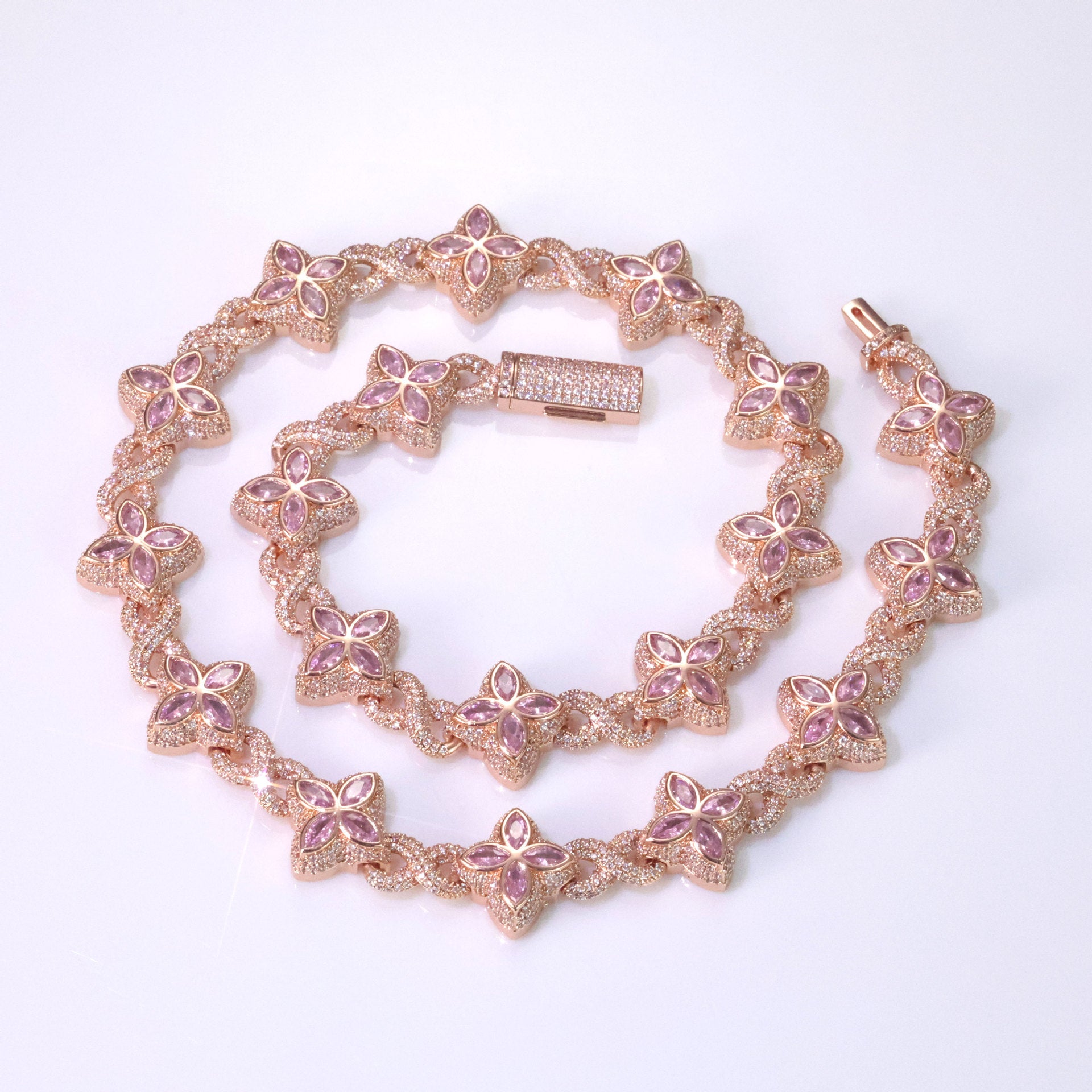 An iced out luxury big clover necklace, infinity symbol, design in clovers with pink maquise stone. Iced out box clasp. Brass with rose gold plating.