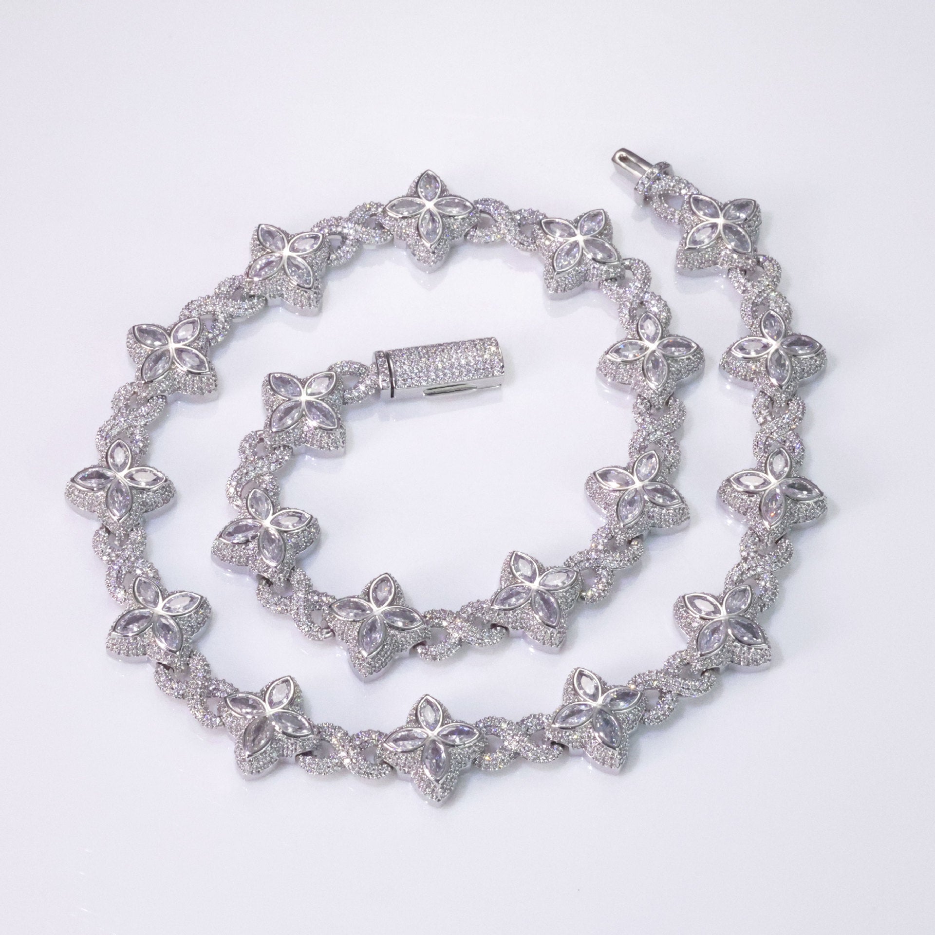 An iced out luxury big clover necklace, infinity symbol, design in clovers with white maquise stone. Iced out box clasp. Brass with silver plating.