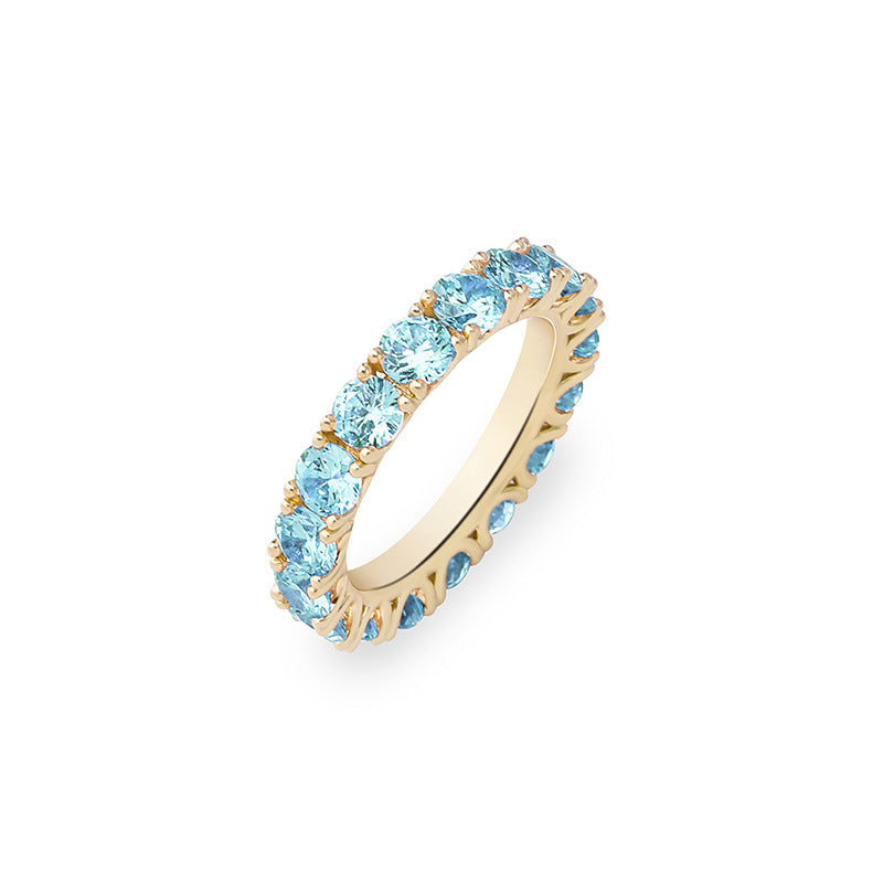 A gold plating brass stacking ring inlaid with blue round brilliant cubic zirconias.