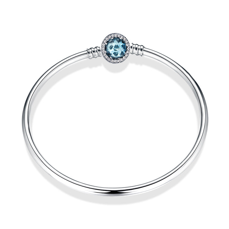 A sterling silver bangle bracelet, the box clasp design in many hearts with blue glass.