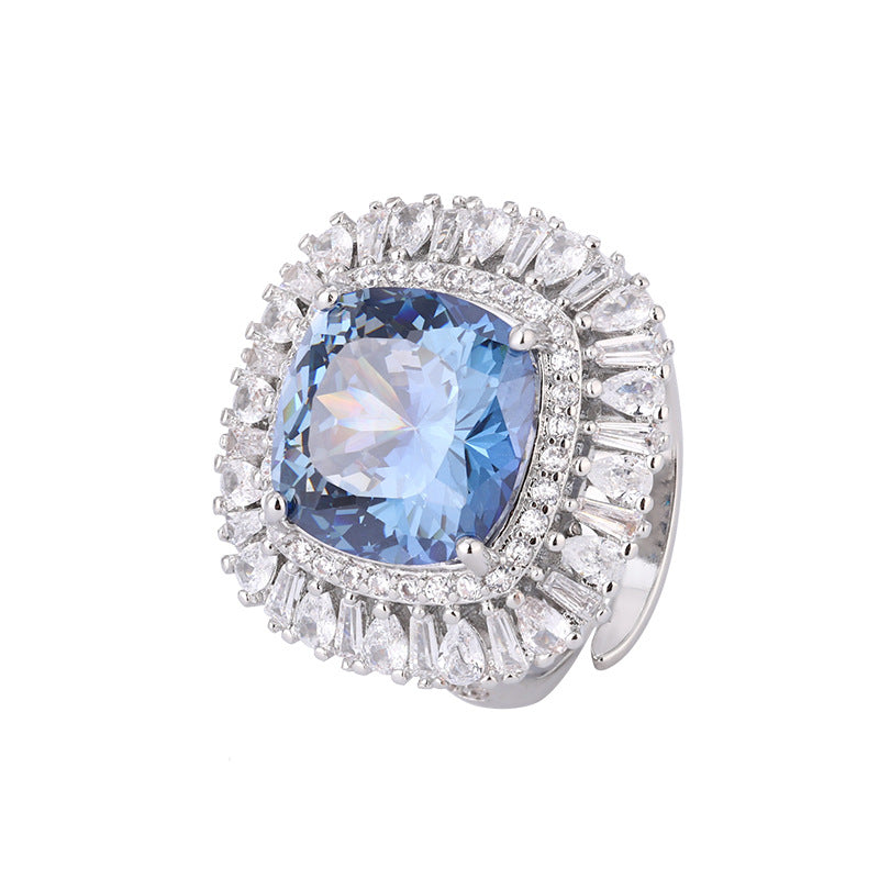 The cocktail ring of the blue sapphire zirconia jewelry set, halo design with a blue center stone and white zirconias. Brass with silver plating.