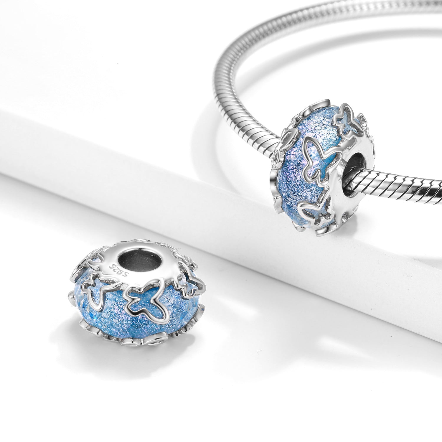 A sterling silver sparkling glazed charm, design in butterfly and blue river
