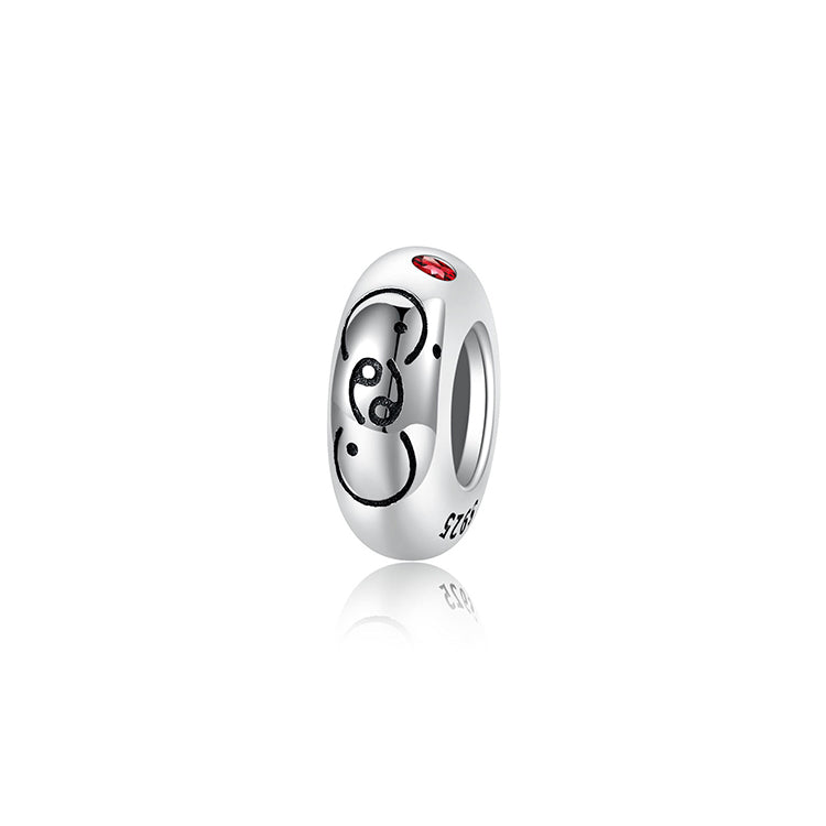 A sterling silver spacer bead, design in Cancer pattern and red birthstone.