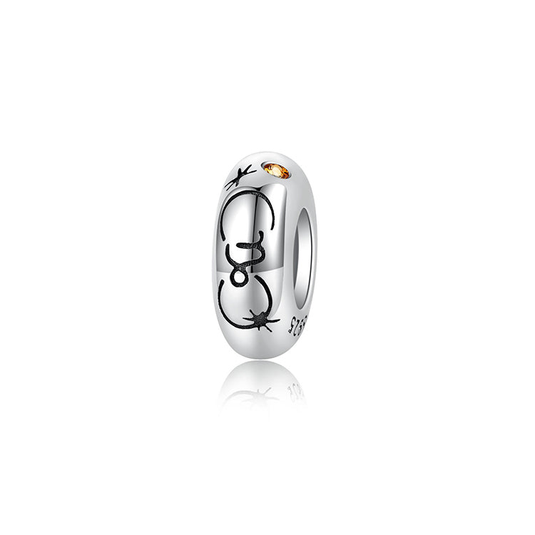A sterling silver spacer bead, design in Capricorn pattern and orange birthstone.