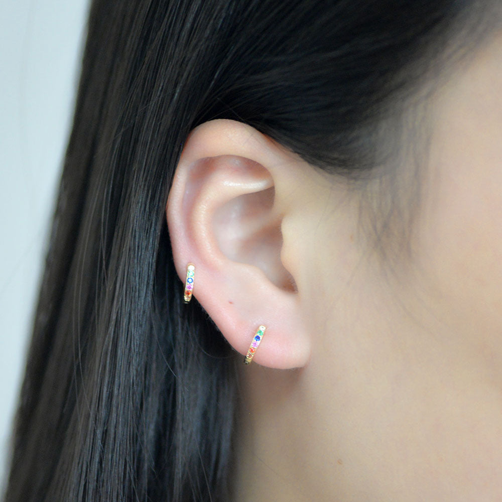 The model showcases the colorful hoop with gold plating.