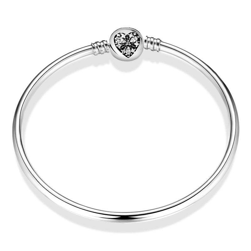 A sterling silver bangle bracelet, the box clasp design in heart with many zirconias.