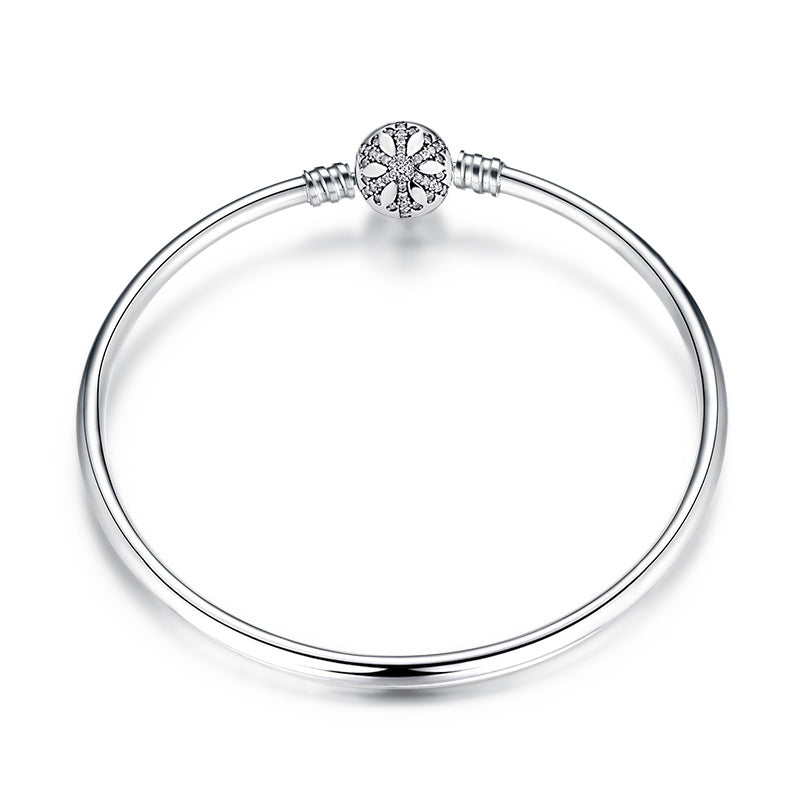 A sterling silver bangle bracelet, the box clasp design in snow flake with pave zirconias.