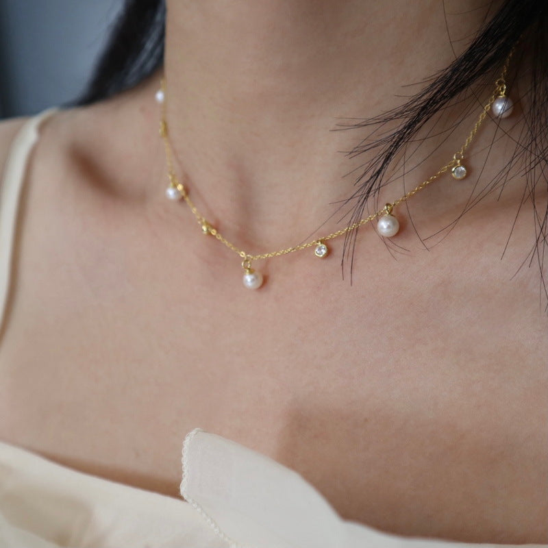 The model showcases the pearl choker with gold plating.