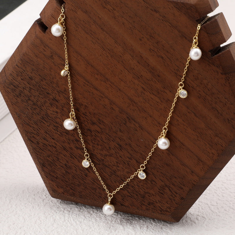 A gold plating silver pearl choker. Cable chain with many hanging white zirconia and pearl.