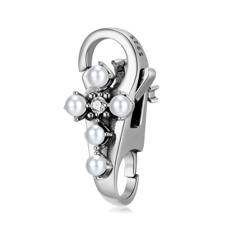 A sterling silver lobster clasp in a cross design with imitation pearls on the cross.
