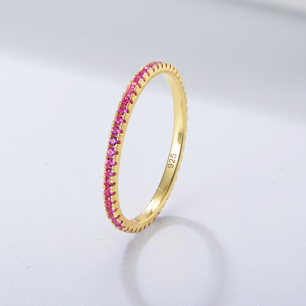 A sterling silver eternity ring band, inlaid with pink zirconias. Plating with gold.