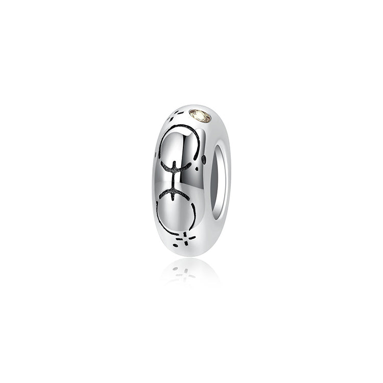 A sterling silver spacer bead, design in Pisces pattern and beige birthstone.