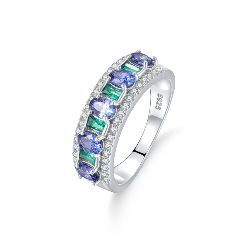 A sterling silver gemstone ring, inlaid with synthetic sapphire and green zirconias. Plating with silver.