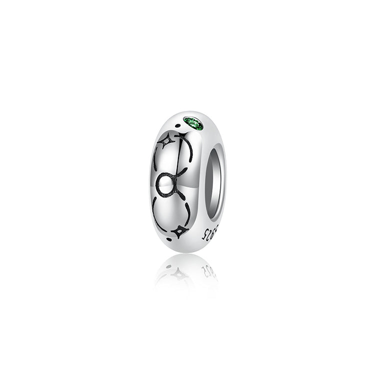 A sterling silver spacer bead, design in Taurus pattern and green birthstone.