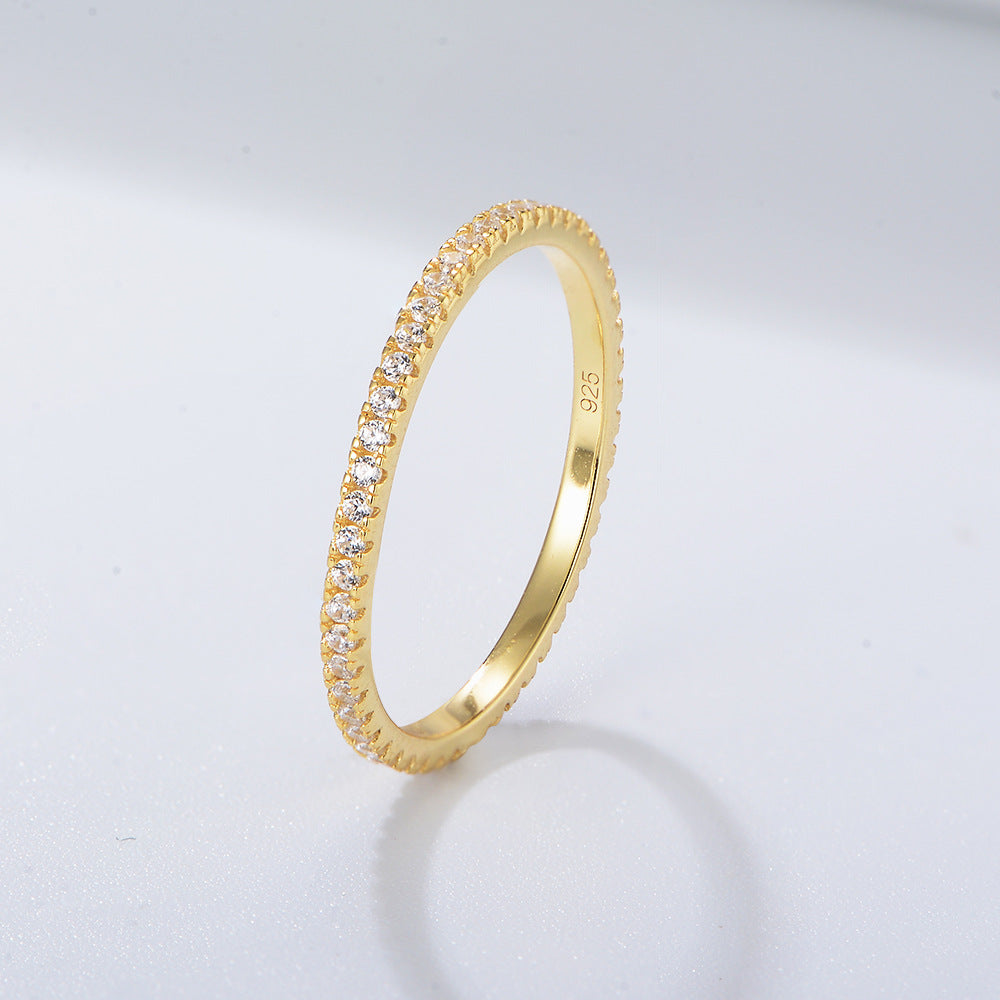 A sterling silver eternity ring band, inlaid with white zirconias. Plating with gold.