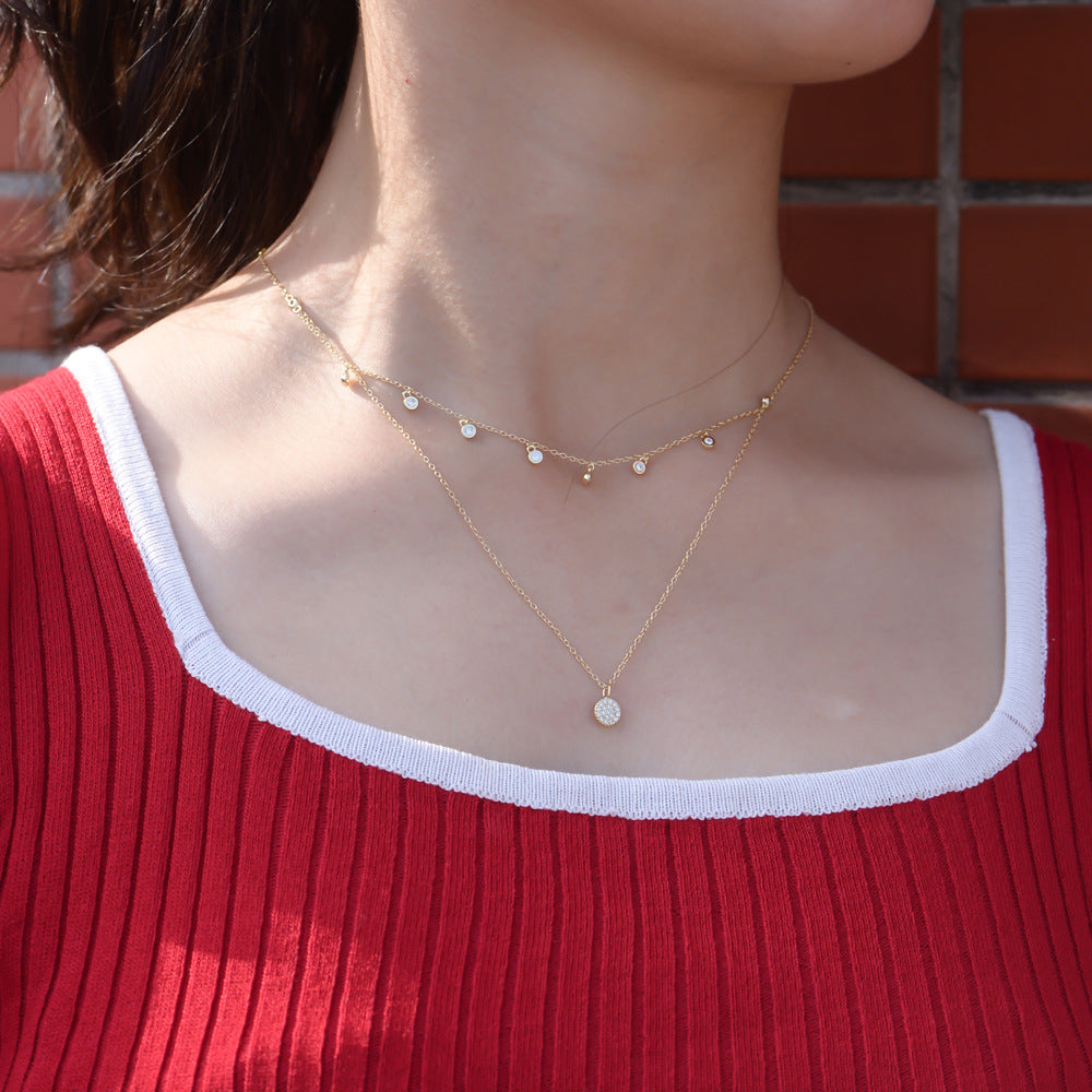 The model showcases the zirconia layered necklace with gold plating.