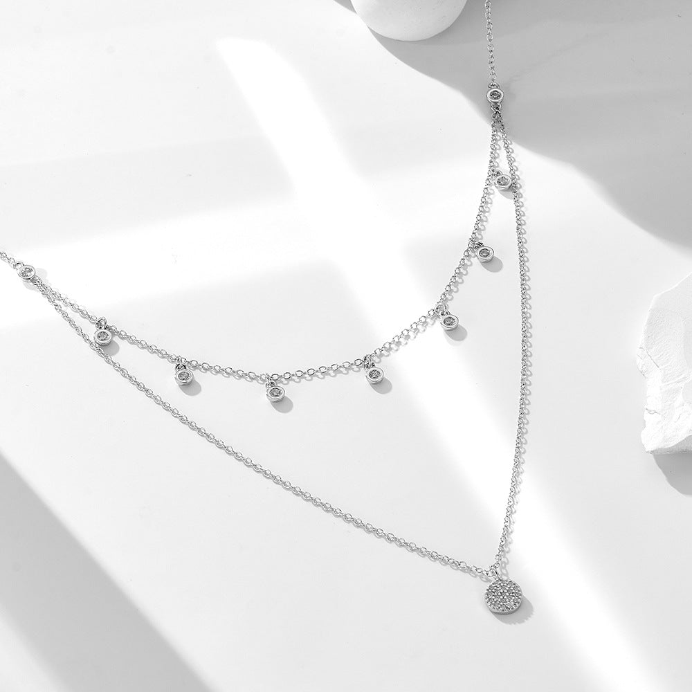 A sterling silver layered necklace with many white zirconias, silver plated.