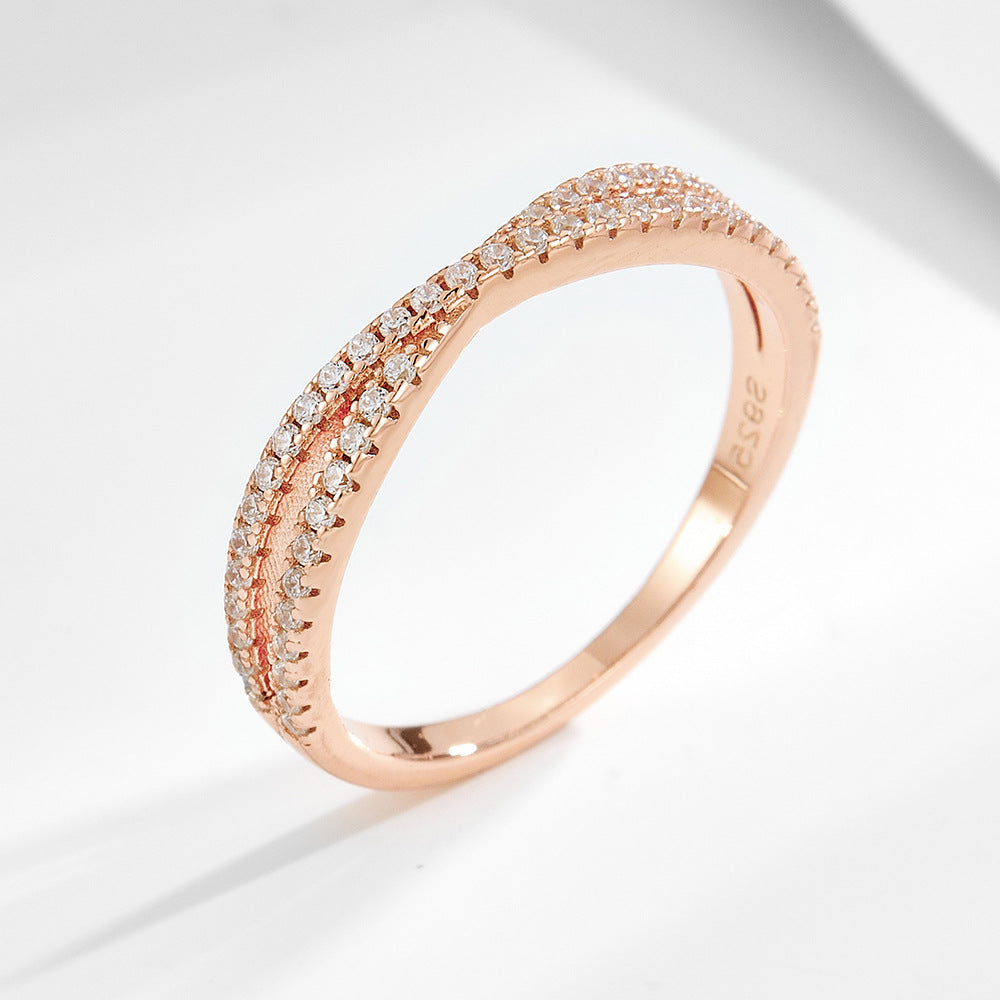 A sterling silver white zirconia cross-designed band, secondary ring of the ring set. Plating with rose gold.