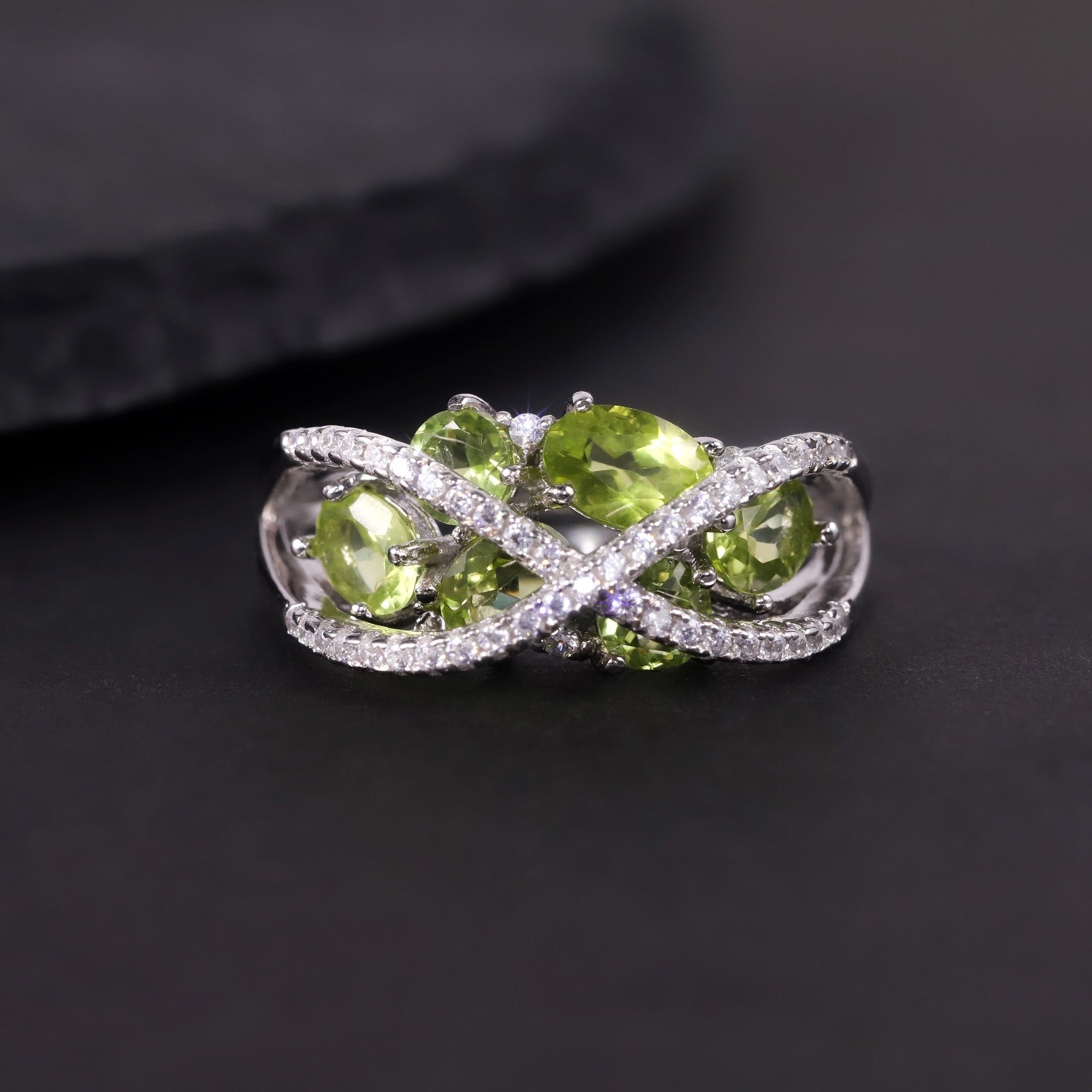 A sterling silver peridot ring, six natral peridots are inlaid in middle, a pave cross design above the stone. Plating with Rhodium.