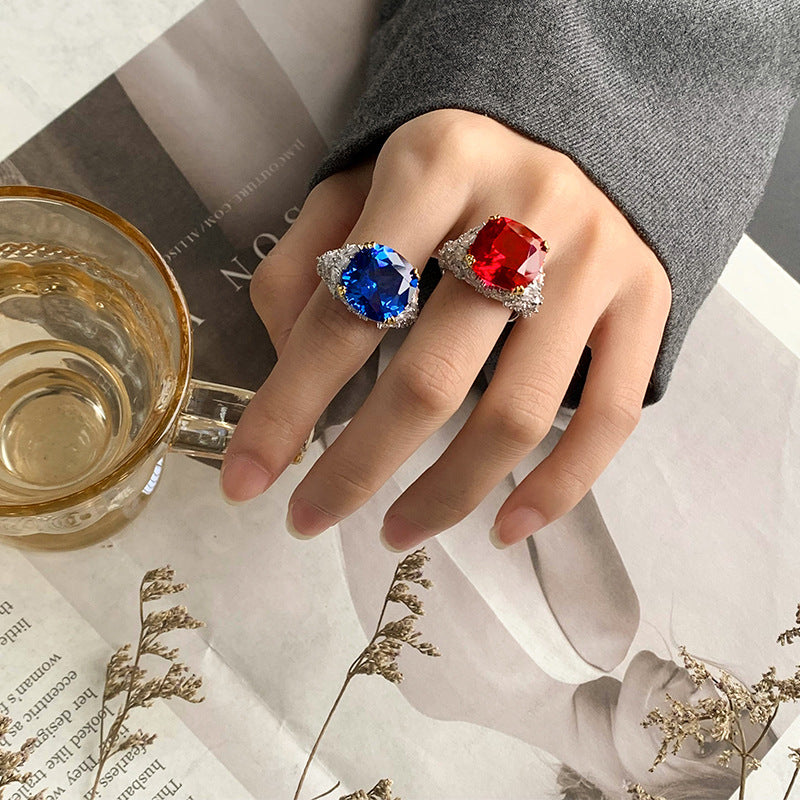 The model showcases the blue and red zirconia cocktail rings.