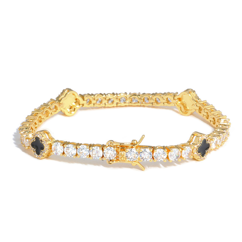 An enamel clover motifs tennis bracelet.  Black enamel clover motifs with white zirconias. Brass with gold plating.