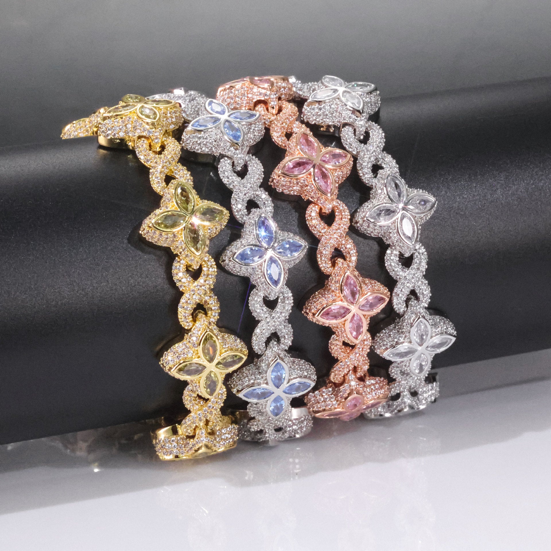 Iced out luxury big clover bracelets, infinity symbol, colored maquise stone design clover in the color of light aquamarine, peridot, white and pink zirconias. Iced out box clasp. Brass with gold, silver, rose gold plating. 